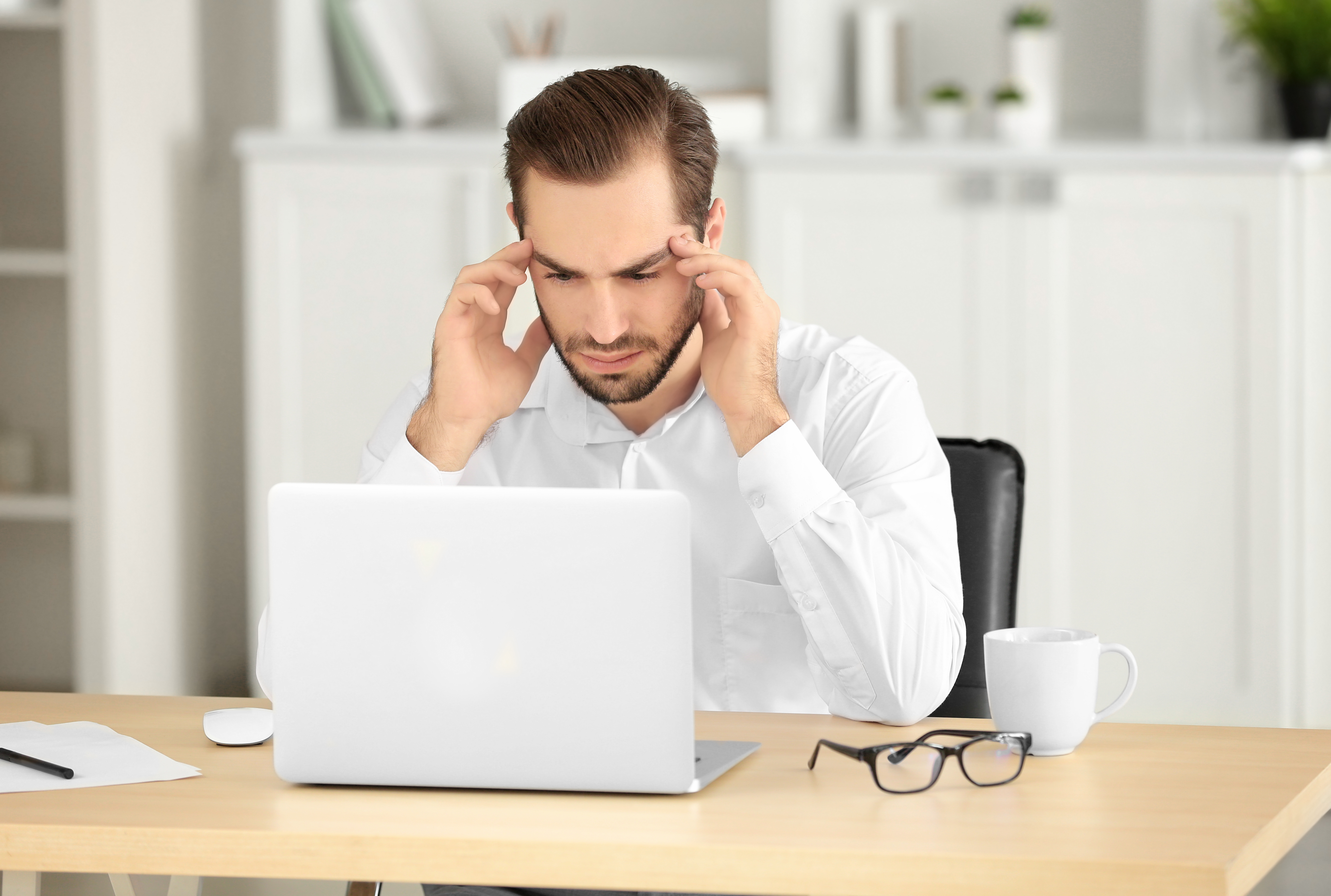 Tired man with laptop in office